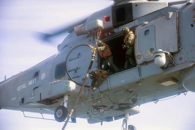 Helicopter crew from 814 Naval Air Squadron attach the fuel line to the Merlin. Photo: Royal Navy