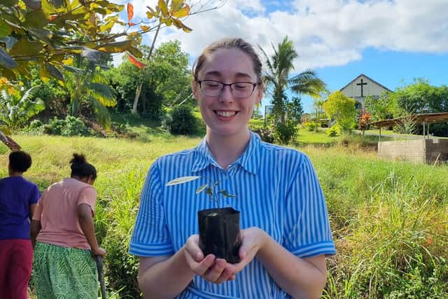 Bobby planting a lemon tree on her trip.