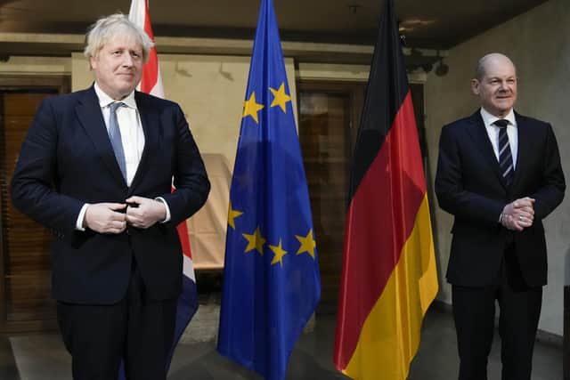 Prime Minister Boris Johnson and German Chancellor Olaf Scholz, (right) pose for photographs ahead of their meeting at the Munich Security Conference in Germany where he is meeting with world leaders to discuss tensions in eastern Europe. Picture date: Saturday February 19, 2022.