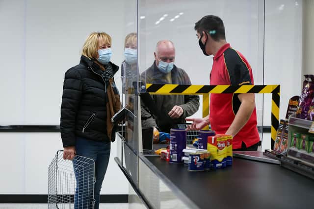 Denise Jones at the checkout. Farmfoods on Fratton Rd has reopened after being refurbishedPicture: Chris Moorhouse      (121220-10)