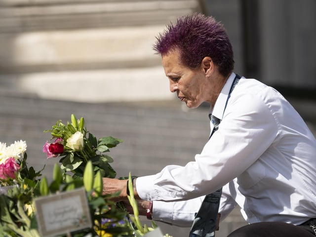 A guest lays flowers in the Queen's memory.