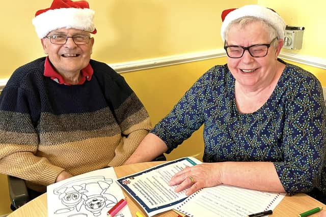 A resident with their Christmas letter to share festive wishes with someone in another home.