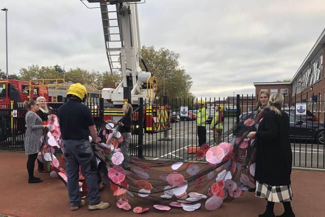 Crew from Southsea Fire Station helping assemble the poppy art installation at Ayrton Ark Academy