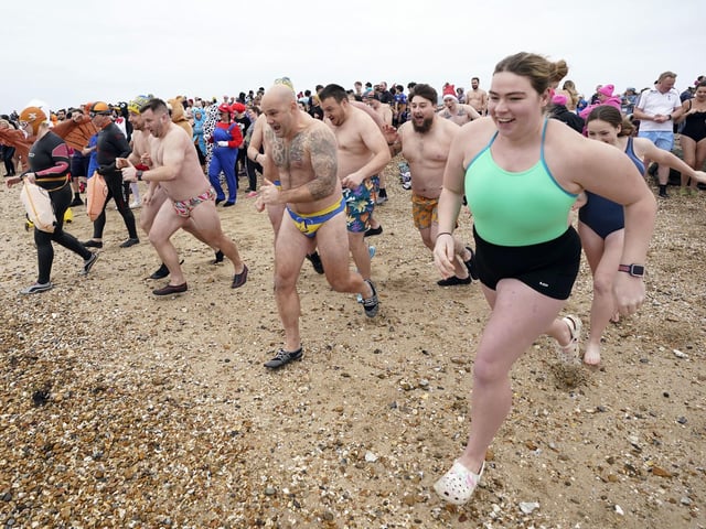 People run into the sea as they take part in the Gosport New Year's Day Dip in The Solent at Stokes Bay, Gosport, Hampshire, to raise money for Gosport and Fareham Inshore Rescue Service.
