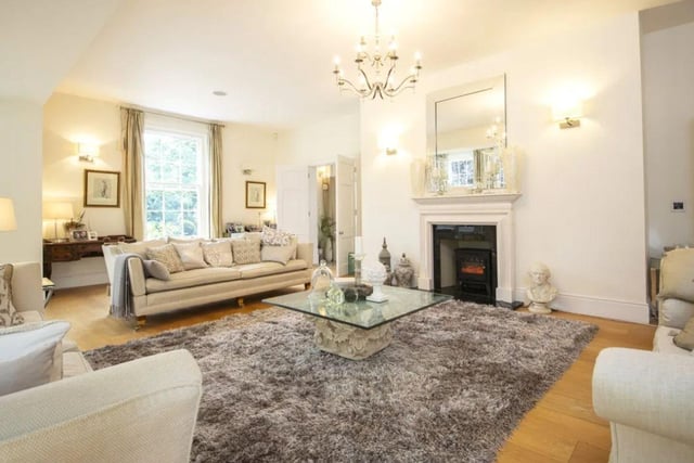 The listing says: "The drawing room is supremely elegant and features a gas fireplace as a focal point whilst light floods in from six windows."