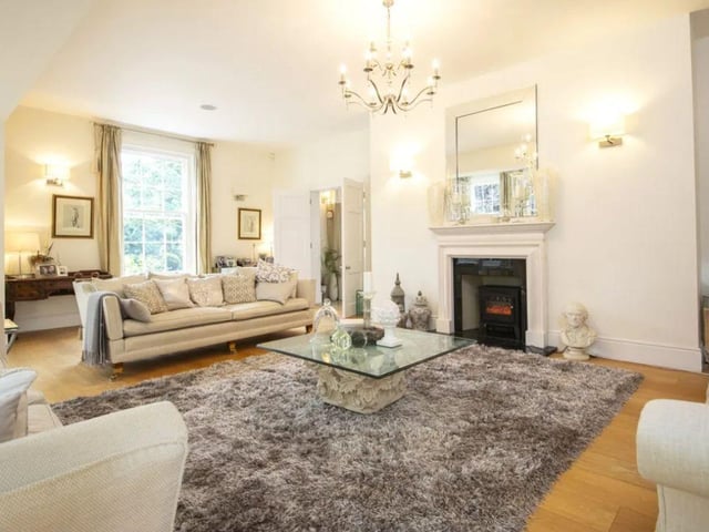 The listing says: "The drawing room is supremely elegant and features a gas fireplace as a focal point whilst light floods in from six windows."