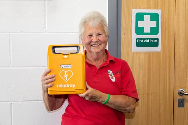 Elizabeth Humphries, 71, who raised £2,500 by doing a sponsored wing walk, pictured with the defibrillator she donated. Picture: Mike Cooter (240921)
