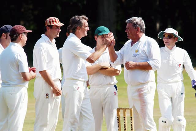 Jim Smallbone (second right) has just bagged another wicket for Petersfield.