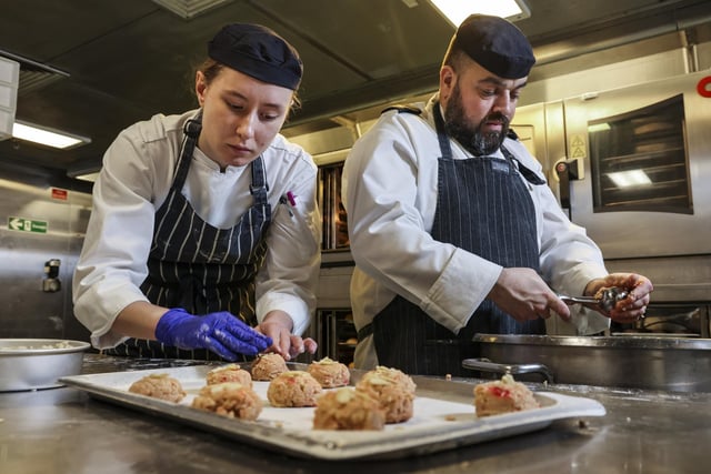 Part of the galley team on board HMS Queen Elizabeth, Leading Chef Humphries, CS Coult and CS Brook bake hundreds of bread rolls for ship's company as well as a batch of popular bakewell cookies.
