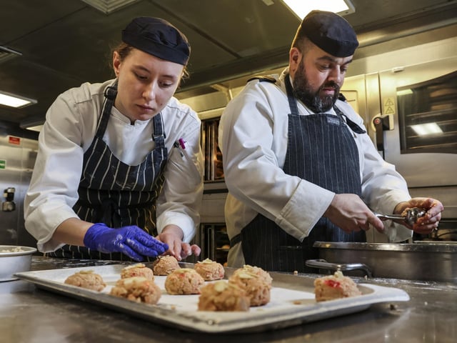 Part of the galley team on board HMS Queen Elizabeth, Leading Chef Humphries, CS Coult and CS Brook bake hundreds of bread rolls for ship's company as well as a batch of popular bakewell cookies.