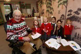 Resident Colin Filmer in his Christmas Jumper pictured with children from Sarisbury Infants School