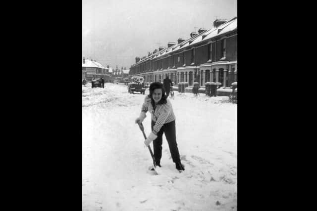 Wendy Stacey clearing snow in Fawcett Road, Southsea, winter 1963.