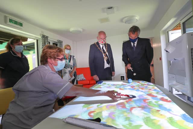 Gosport Mayor Mark Hook and Lord Lieutenant of Hampshire Nigel Atkinson pictured in the activities room with Janet Woods, activities coordinator. They are using the Mobii Magic Table manufactured by OM Interactive. Picture: Stuart Martin (220421-7042)