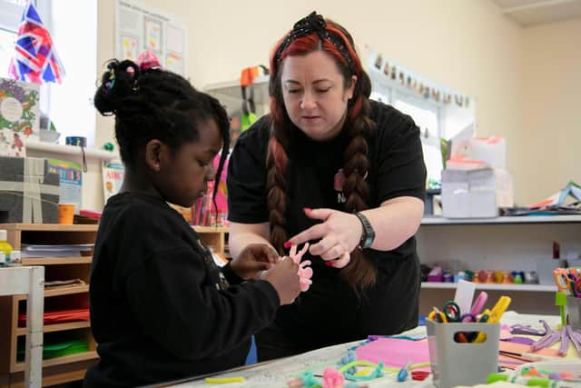 Nancy Fellows helps a participant at a creative community workshop for young people