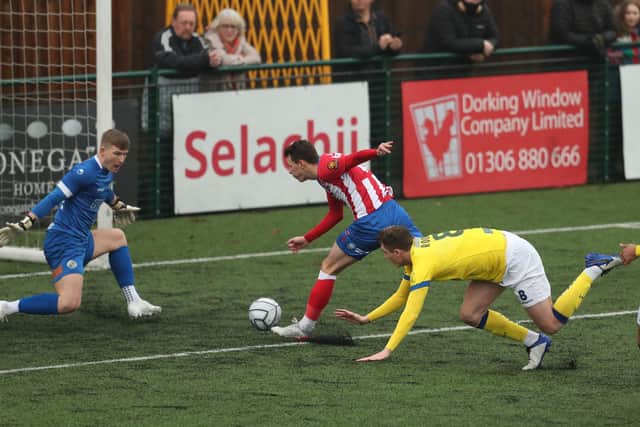 Dorking's Alfie Rutherford gets pushed by Hawks defender Paul Rooney, who will be sent off for the foul. Picture: Dave Haines