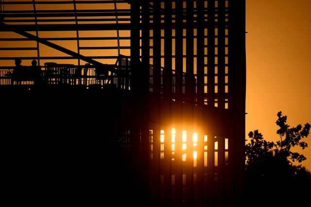 Spectators look on as the sun sets during The Hundred match between Southern Brave Men and Oval Invincibles Men at The Ageas Bowl. Photo by Harry Trump/Getty Images.