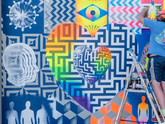 Mark Kellet, a lecturer at Havant & South Downs College, puts the finishing touches on a mural created with a group of LGBTQIA+ youth groups from the college.  Picture: Nuno Cardoso