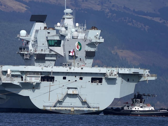 The Royal Navy aircraft carrier HMS Queen Elizabeth leaving Glen Mallan in Loch Long with the Arrochar Alps behind.