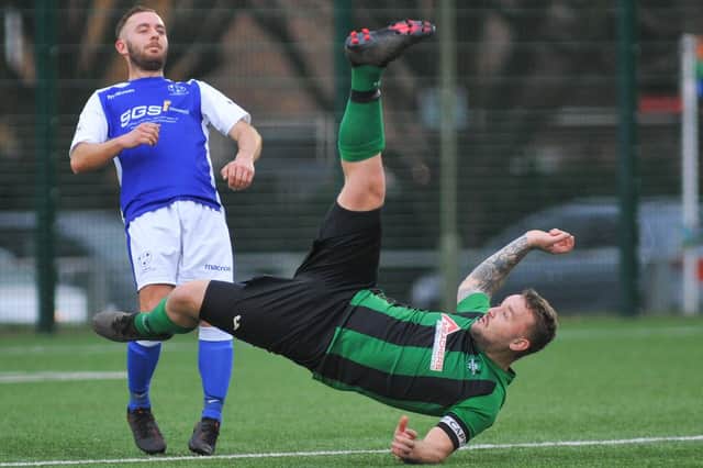 Denmead's Danny Lucas looks on as a Lyndhurst player acrobatically clears. Picture: Martyn White