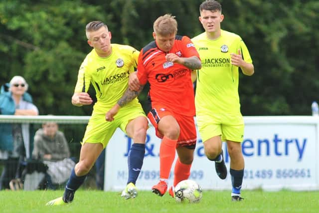 Portchester's Jake Raine is outnumbered against Horndean. Picture: Martyn White