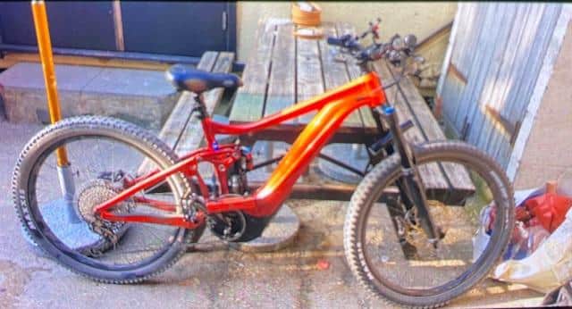 The stolen bike (pictured) is described as a Giant Reign e-bike E+1 Pro in orange and red.