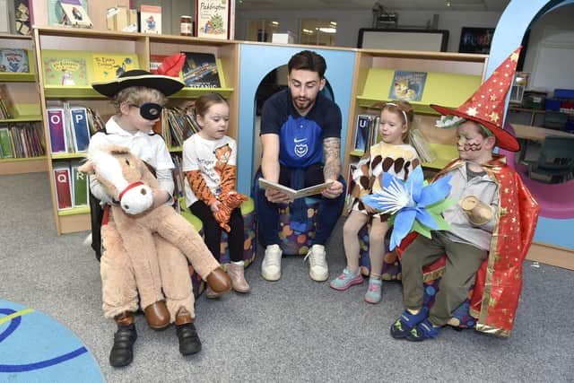 Pictured is: (middle) PFC player Owen Dale reading to some of the children.
Picture: Sarah Standing (020323-622)
