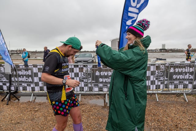Caroline Jarvis (29) presents a medal to husband Ben Jarvis (33) after finishing the Langstone Harbour Half Marathon Picture: Mike Cooter (170224)