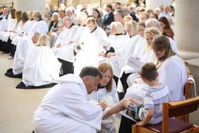 Bishop Jonathan Frost washes the feet of five-year-old Lucas Ashworth
