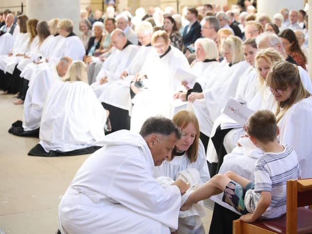 Bishop Jonathan Frost washes the feet of five-year-old Lucas Ashworth