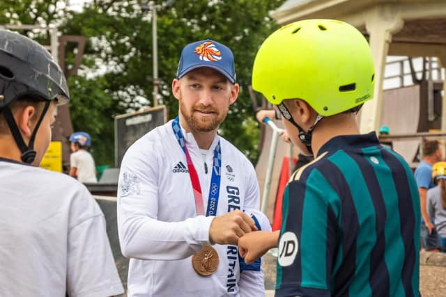 Declan Brooks fist bumps with a young rider at Southsea Skate Park. Picture: Mike Cooter (070821)