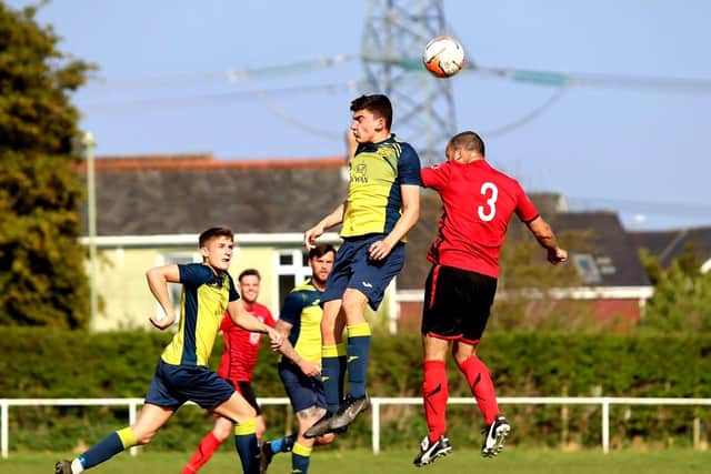 Josh Bailey (yellow) rises for a header as Moneyfields lose at Locks Heath. Picture by Tom Phillips