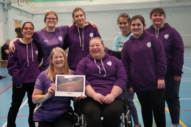 Lucy with her award certificate and some of her players.