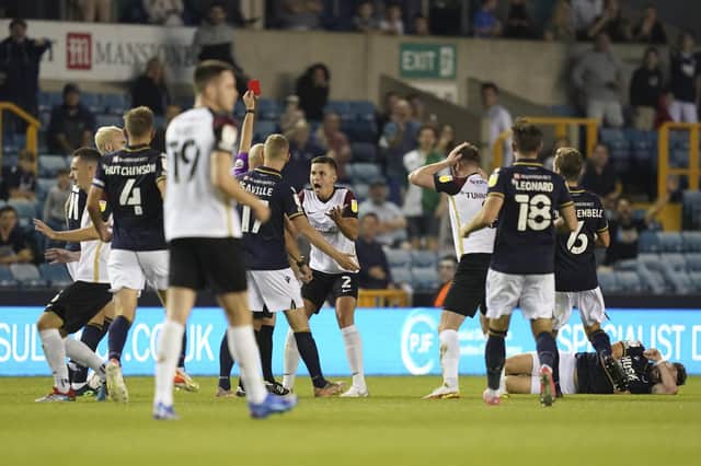 Callum Johnson receives his red card at Millwall