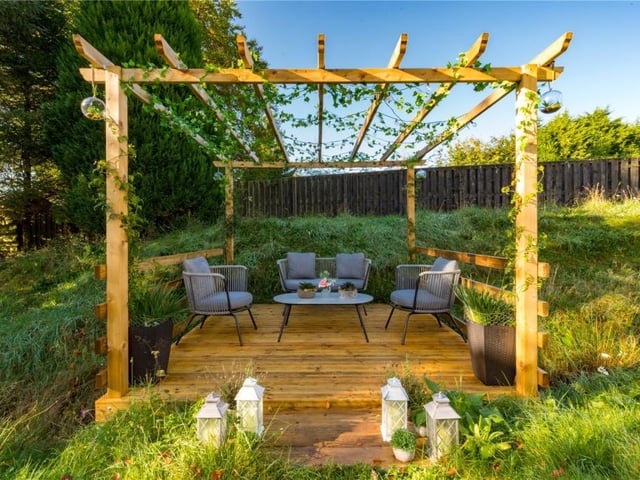 A timber decked entertaining area has been imaginatively built over the burn, doubling up as a bridge to the far bank.