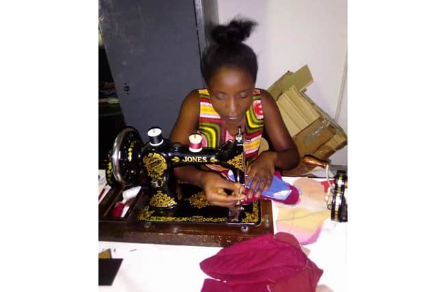 One of the Noah Mapalo Help Centre volunteers stitching pads together to send to Zambia.