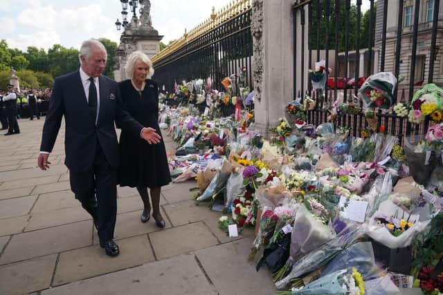 King Charles III and Camilla, Queen Consort view tributes left outside Buckingham Palace, London yesterday Picture: Yui Mok - WPA Pool/Getty Images