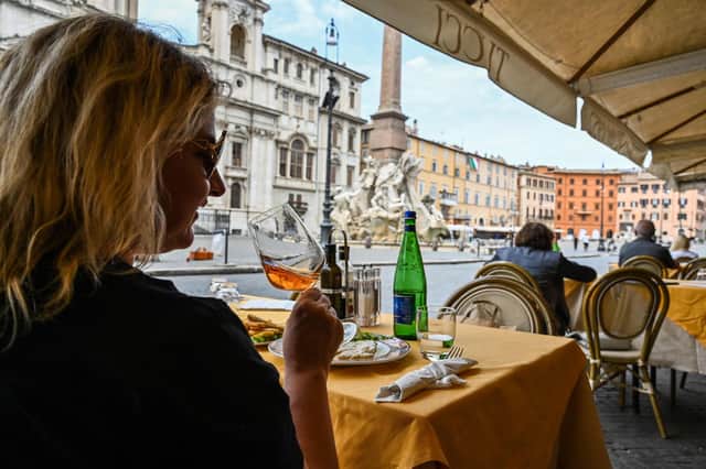 A woman drinks wine and has lunch at a restaurant's terrace on Piazza Navona in central Rome on May 18, 2020 during the country's lockdown aimed at curbing the spread of the COVID-19 infection. (Photo by ANDREAS SOLARO/AFP via Getty Images)