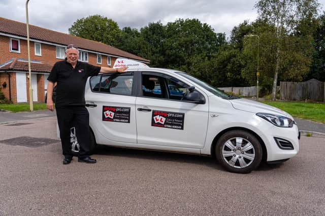 Liam Greaney, founder of Driving Pro, standing in front of a branded instructor's car. Photo by Matthew Clark