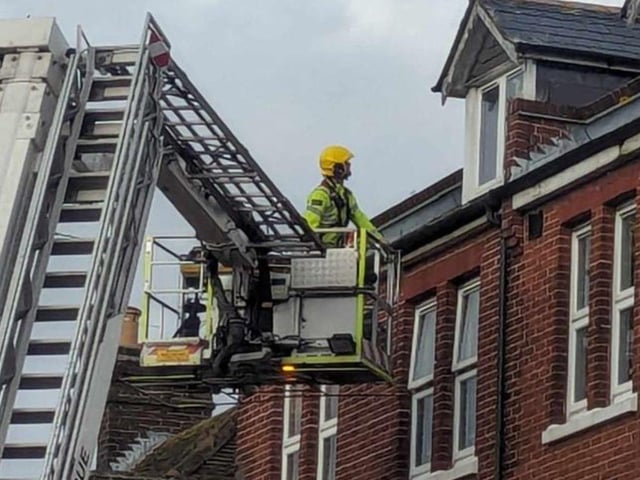 Firefighters fixing loose roof tiles and a sign above Poppins Cafe in North Street, Havant, on January 2.