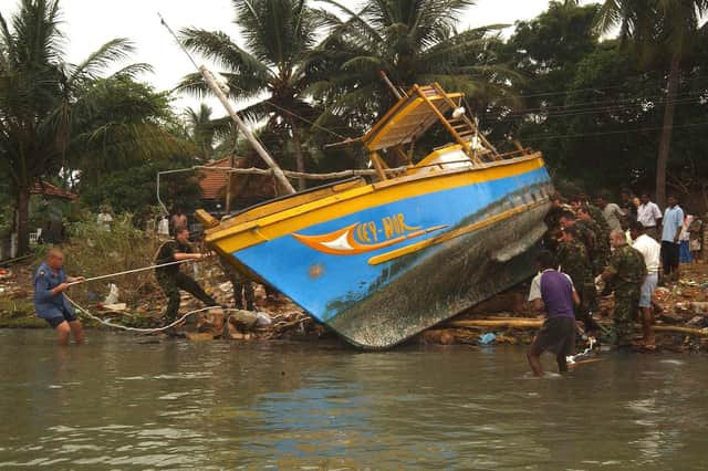 Royal Navy and Royal Fleet Auxillary personnel from HMS Chatham and RFA Diligence provide aid to locals in Batticoloa, one of the worst hit areas in the town by repairing and refloating some of the fishing vessels which have been swept some 2,000m along the shoreline. Photo: Royal Navy