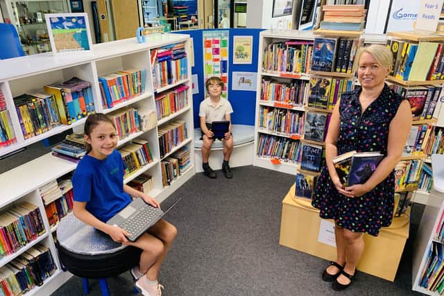 Pupils, Lucia Ashton and Harry Chumley, both 10, in Gomer Junior School's library along with librarian, Maria Kidd.