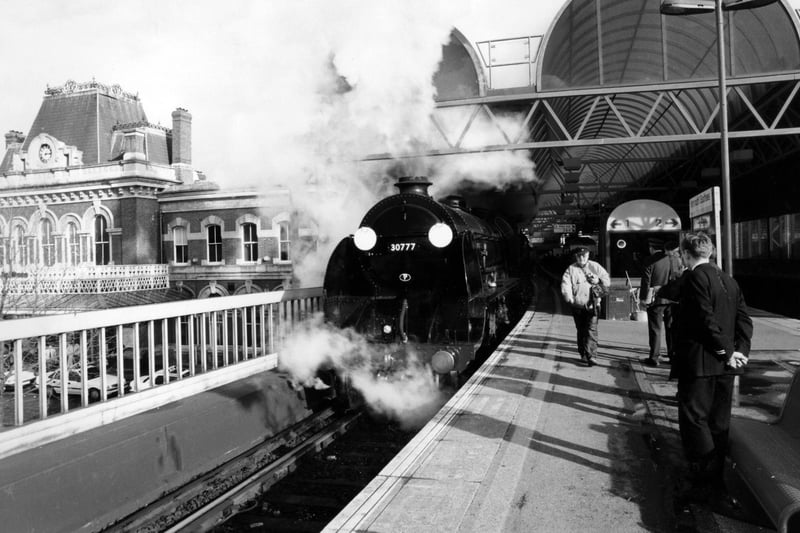 Train enthusiast, Michael Harvey, getting a closer look at the railway steam locomotive Southern Railway 777 Sir Lamiel as it halts for a while on the upper level at Portsmouth & Southsea town station, 1995. The News PP5166
