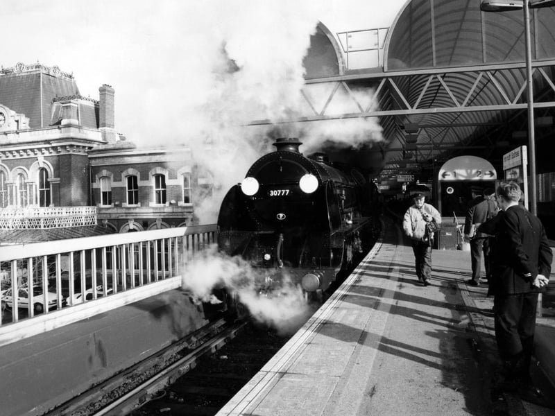 Train enthusiast, Michael Harvey, getting a closer look at the railway steam locomotive Southern Railway 777 Sir Lamiel as it halts for a while on the upper level at Portsmouth & Southsea town station, 1995. The News PP5166