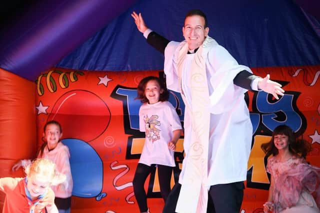 The Rev Luiz Lima on a bouncy castle