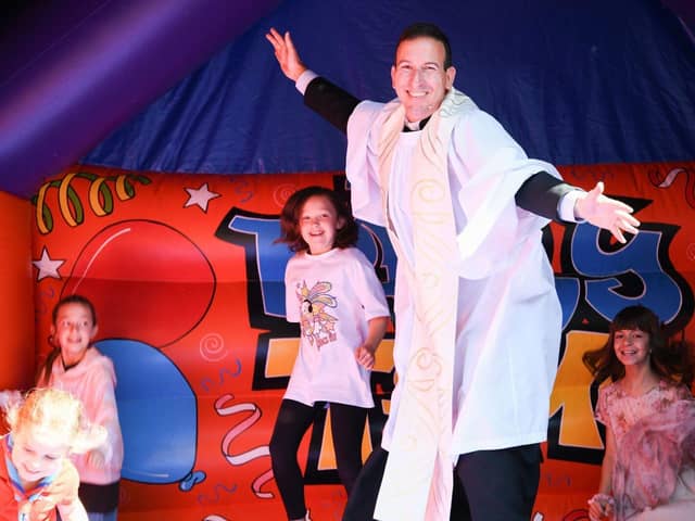 The Rev Luiz Lima on a bouncy castle