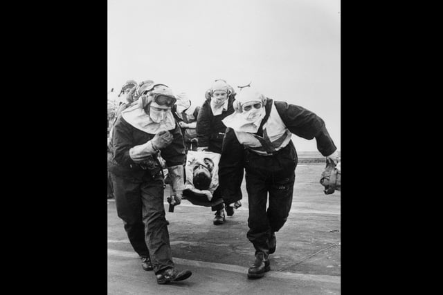 A casualty from HMS Sheffield being rushed to the sick bay on board HMS Hermes.