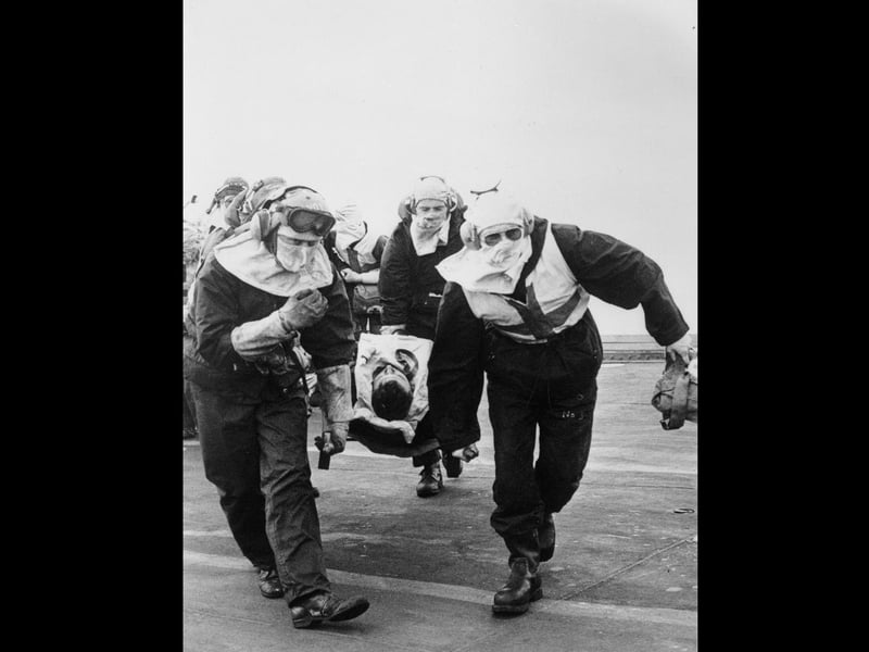 A casualty from HMS Sheffield being rushed to the sick bay on board HMS Hermes.