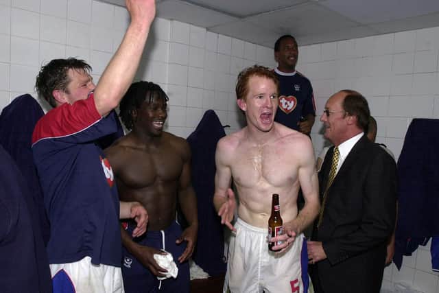 Hayden Foxe leads the party with Linvoy Primus and Arjan De Zeeuw following Pompey's promotion-securing win over Burnley in April 2003. Picture: Steve Reid