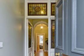 Inside, there’s a classic vestibule with a tiled floor, and stained and leaded-glass panelling, which leads into the hall. Here, there’s stripped floorboards and a ceiling with cornices and a grand arch