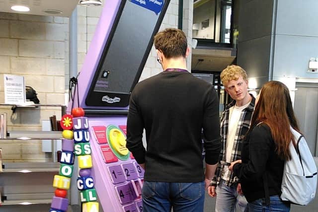 Portsmouth students looking at the giant phone in the University Library
